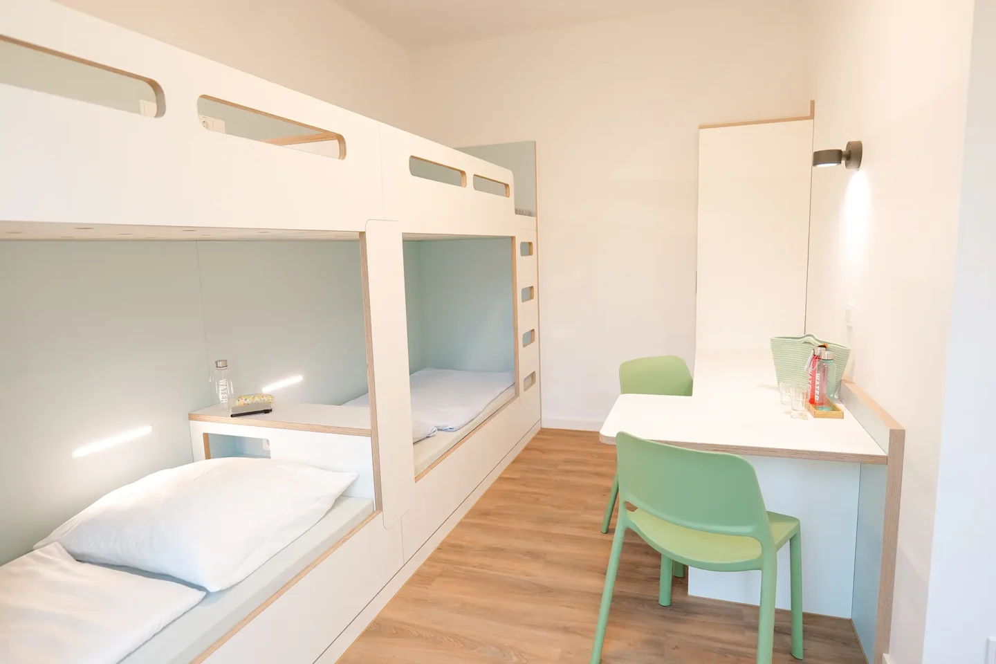 4er Zimmer mit Stockbetten und einem Schreibtisch.