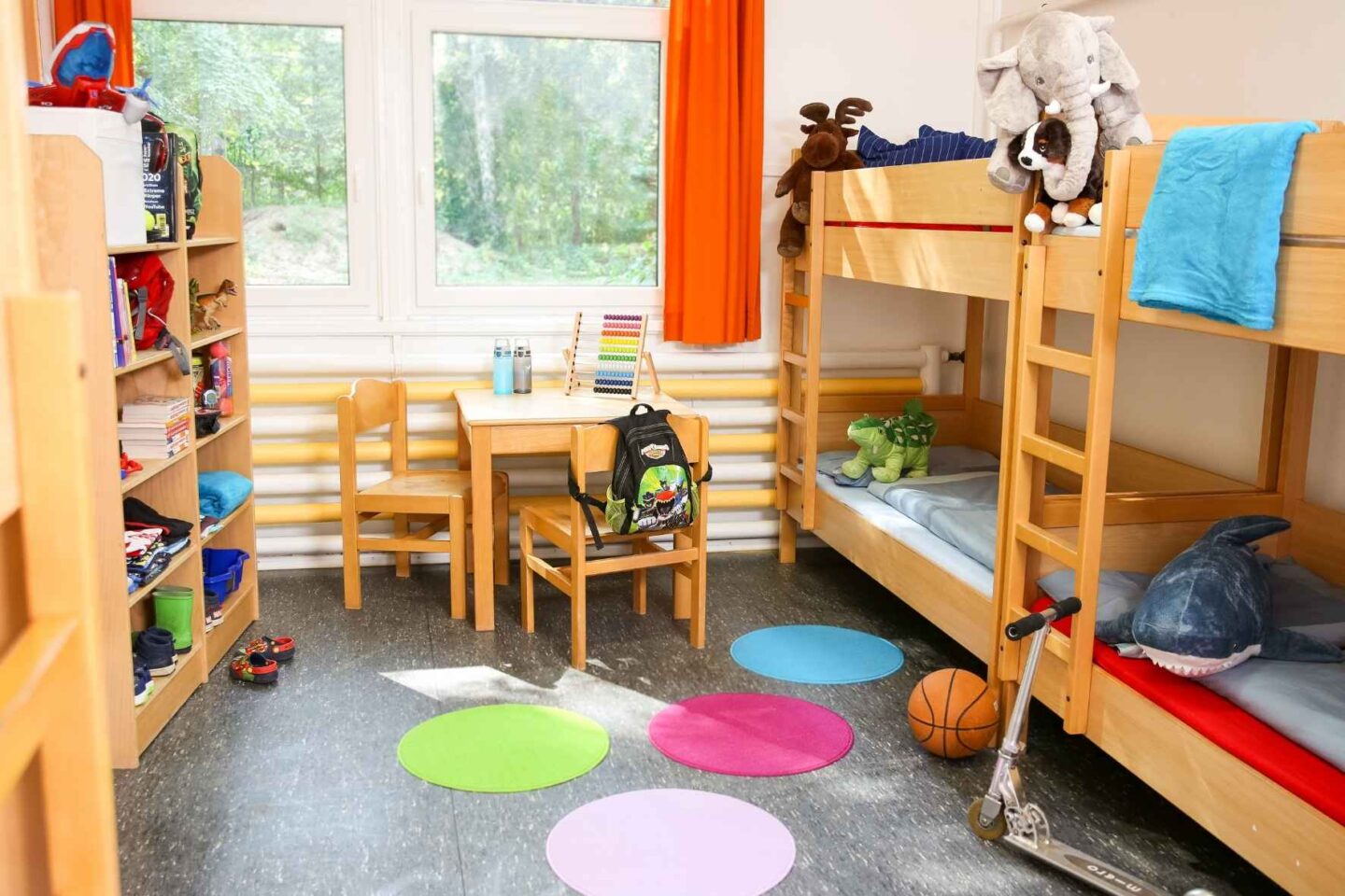 Helles, gemütliches Vierbettzimmer mit Kuscheltieren und Spielzeug in der Freiluftschule Fischbeker Heide.