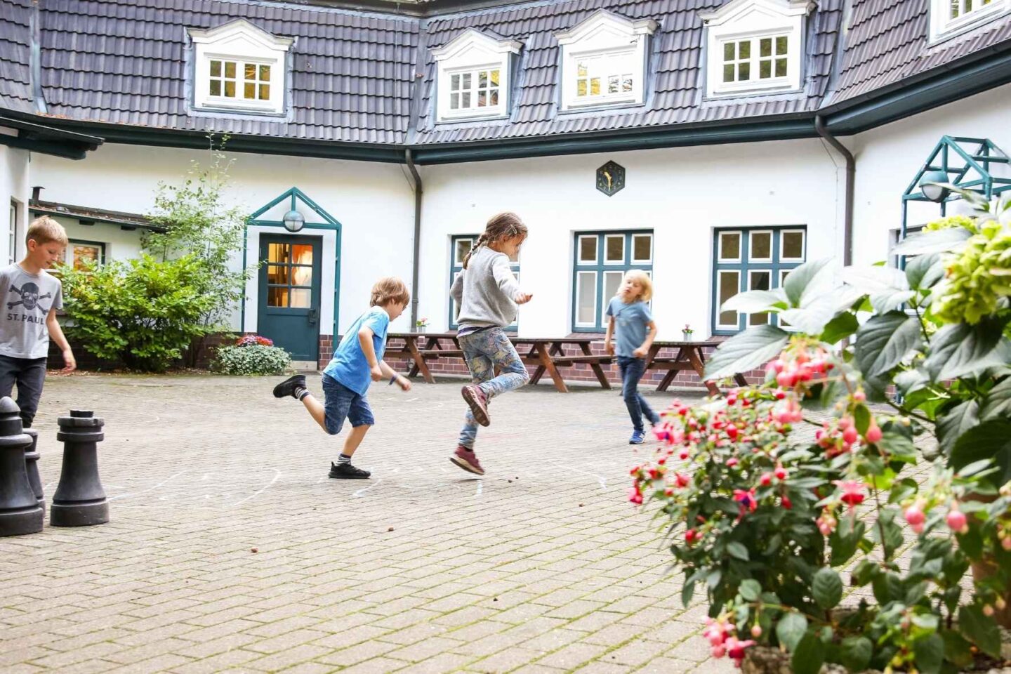 Innenhof der Freiluftschule Wittenbergen, in dem Kinder fröhlich spielen.