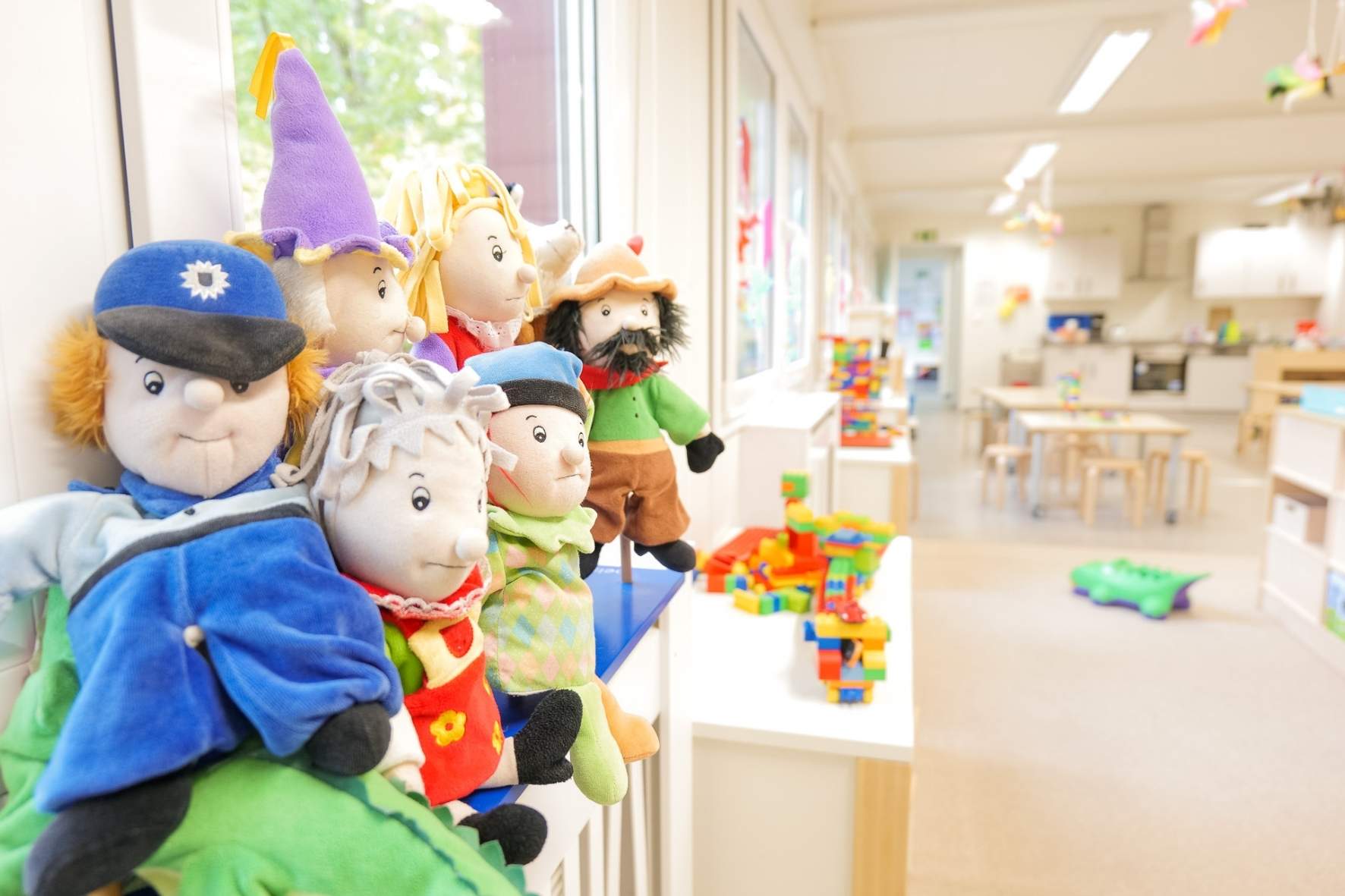 Fröhliche Puppen in der Kita Buckhorn vor einer hellen Kulisse, perfekt für kreatives Rollenspiel.