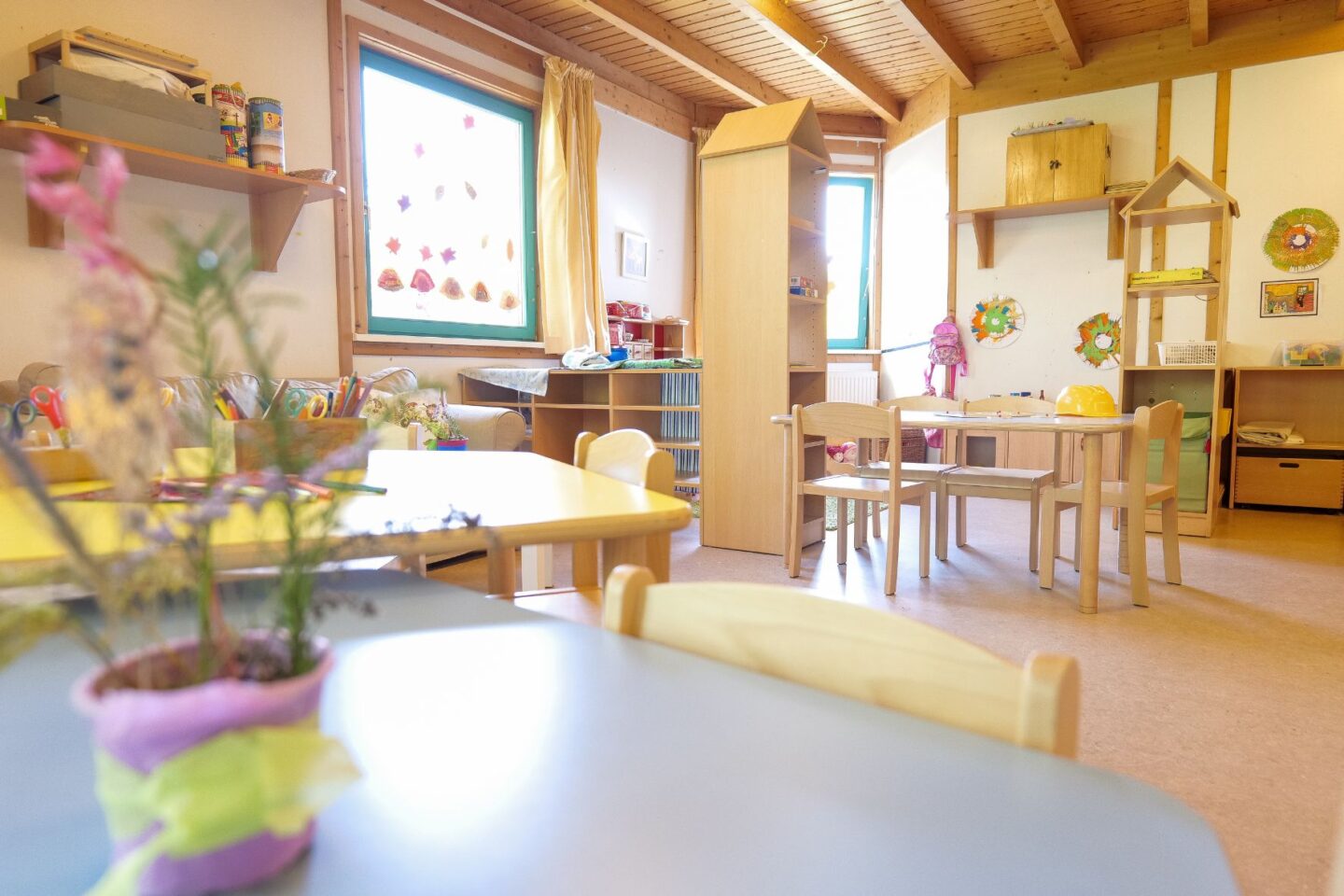 Heller Gruppenraum der Kita Eckerkoppel mit Basteltischen und Fensterdekorationen.