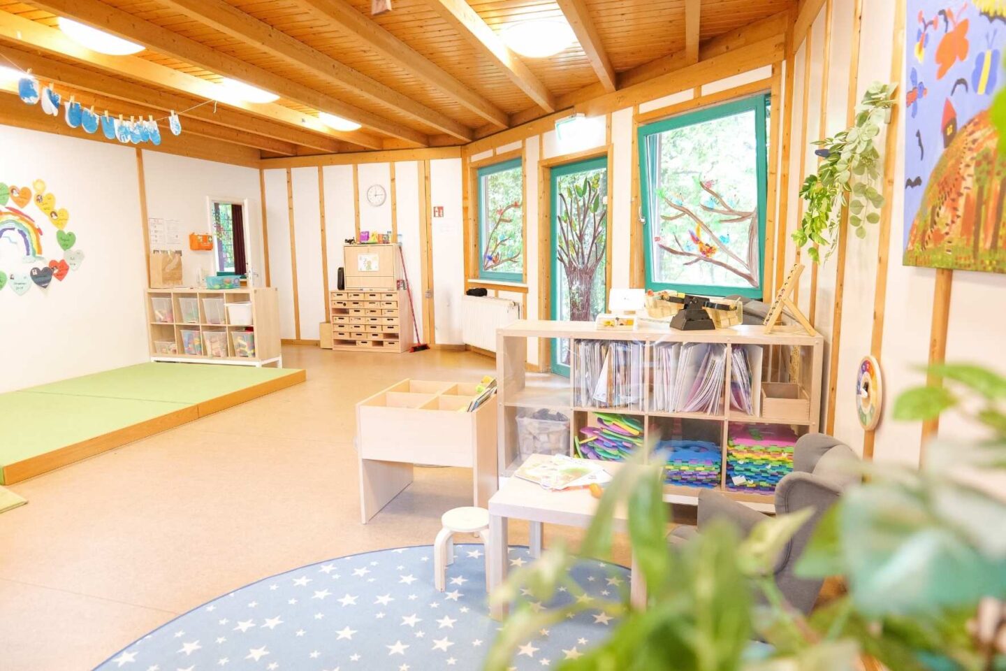 Moderner Gruppenraum in der Kita Osterbrook mit kindgerechten Tischen, Stühlen und bunten Wanddekorationen