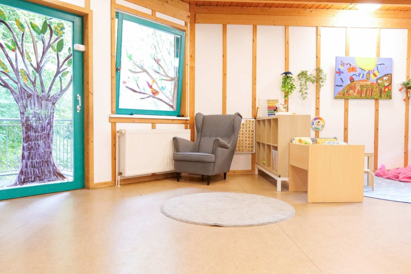Gemütliche Leseecke in der Kita Osterbrook mit einem großen grauen Sessel und Kinderbüchern