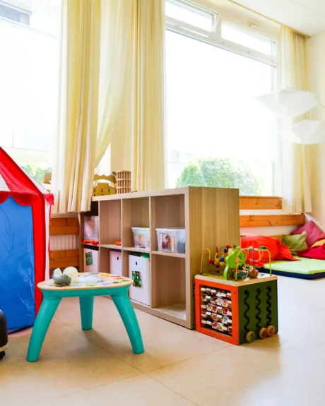 Heller, bunter Gruppenraum mit Spielzelt, Leseecke und Spielzeug in der Kita Schafgarbenweg.