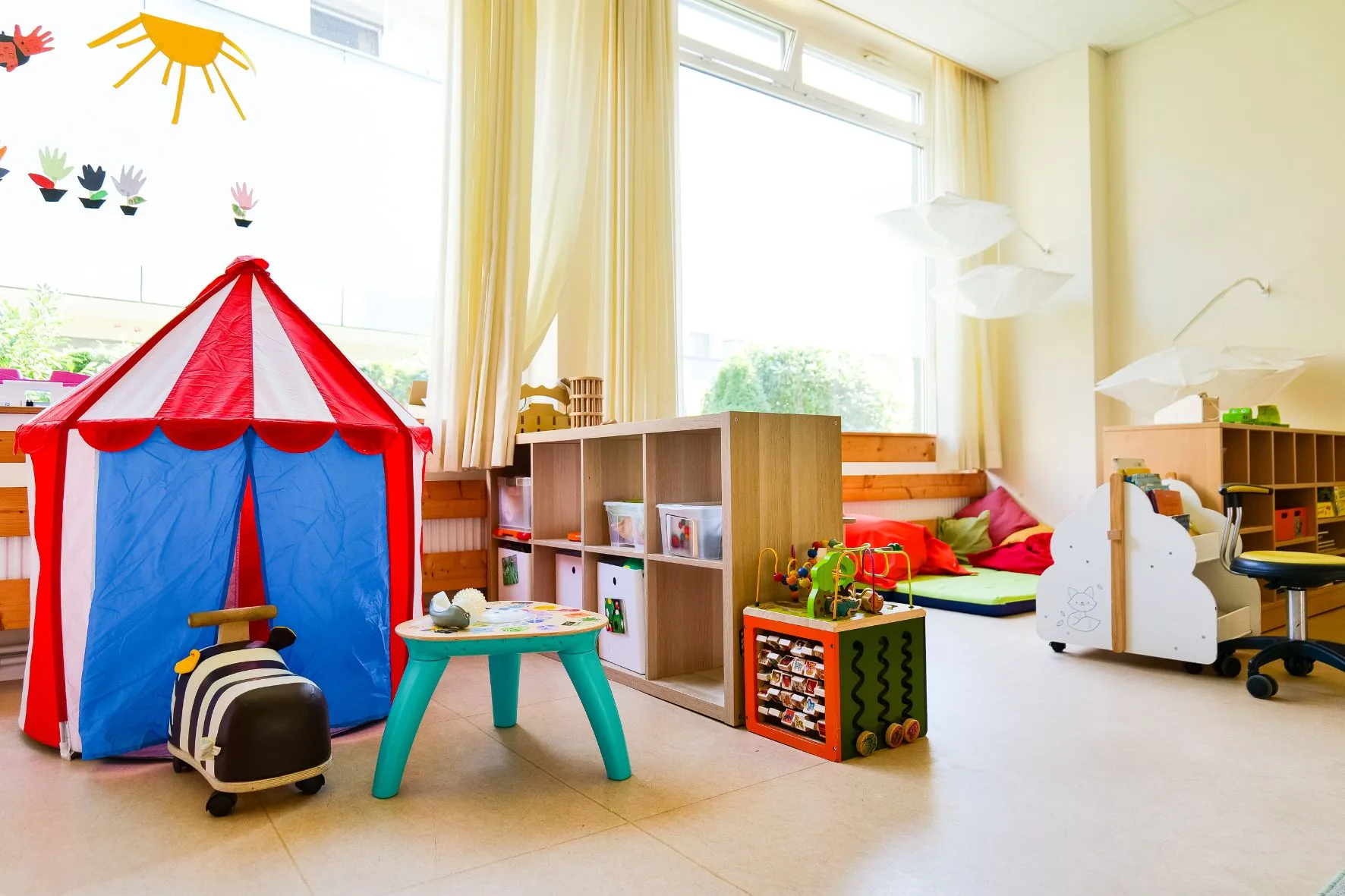 Heller, bunter Gruppenraum mit Spielzelt, Leseecke und Spielzeug in der Kita Schafgarbenweg.