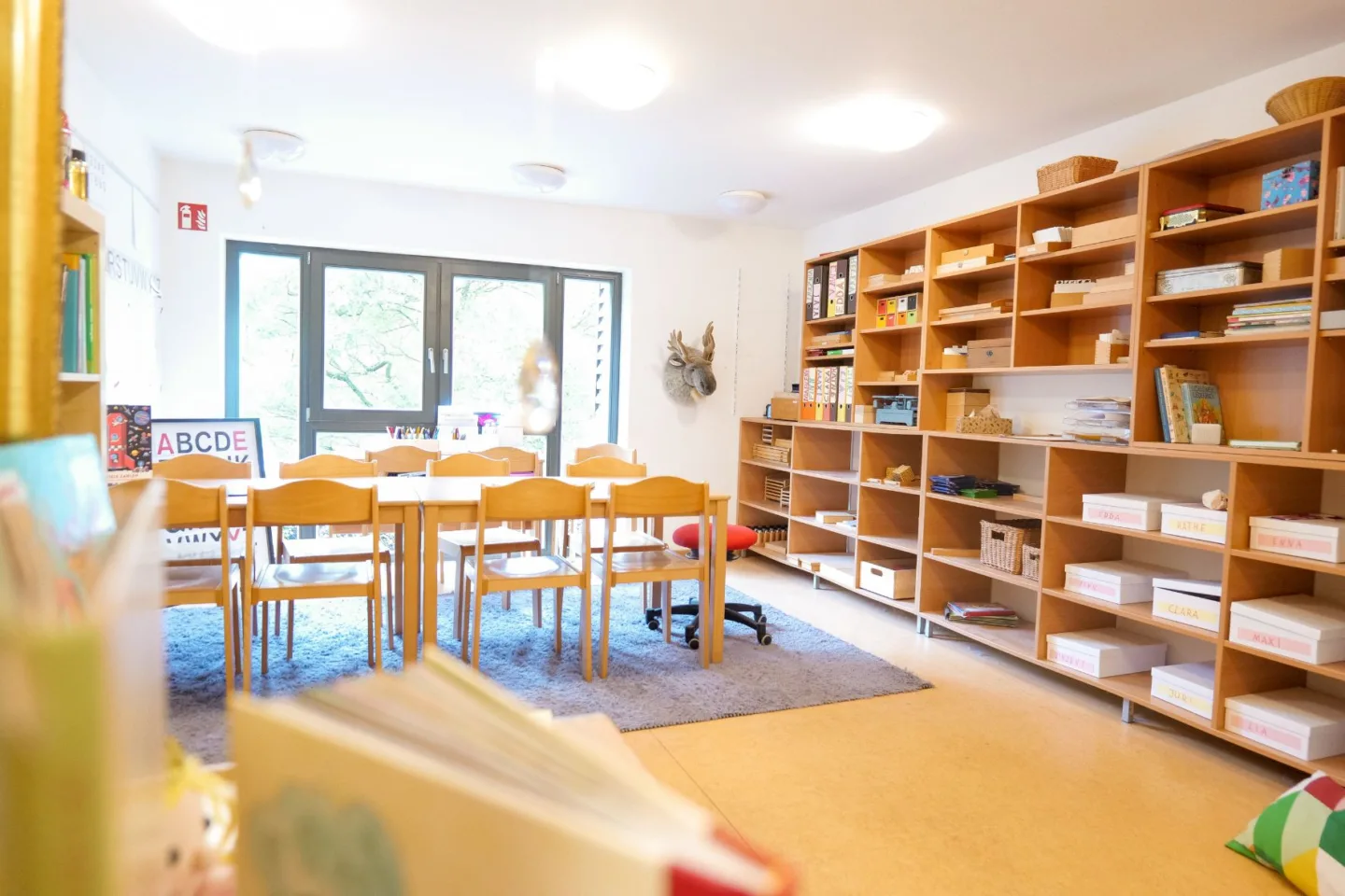 Heller Vorschulraum der Kita Völckersstraße mit Tischgruppen, Regalen und vielen Büchern für die Vorschularbeit.