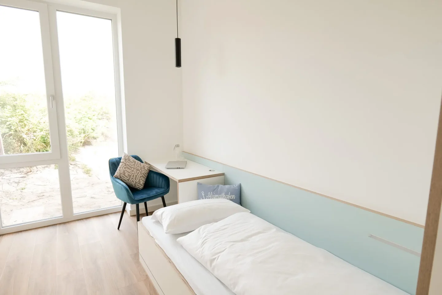 Einzelzimmer mit Schreibtisch und Stuhl für Betreuungsperson.